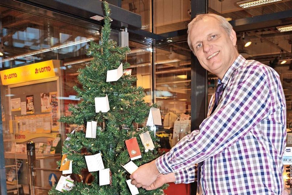 famila-Warenhausleiter Lars Knoop vor dem Weihnachts-Wunschbaum der Timmendorfer Tafel. (Foto: René Kleinschmidt)