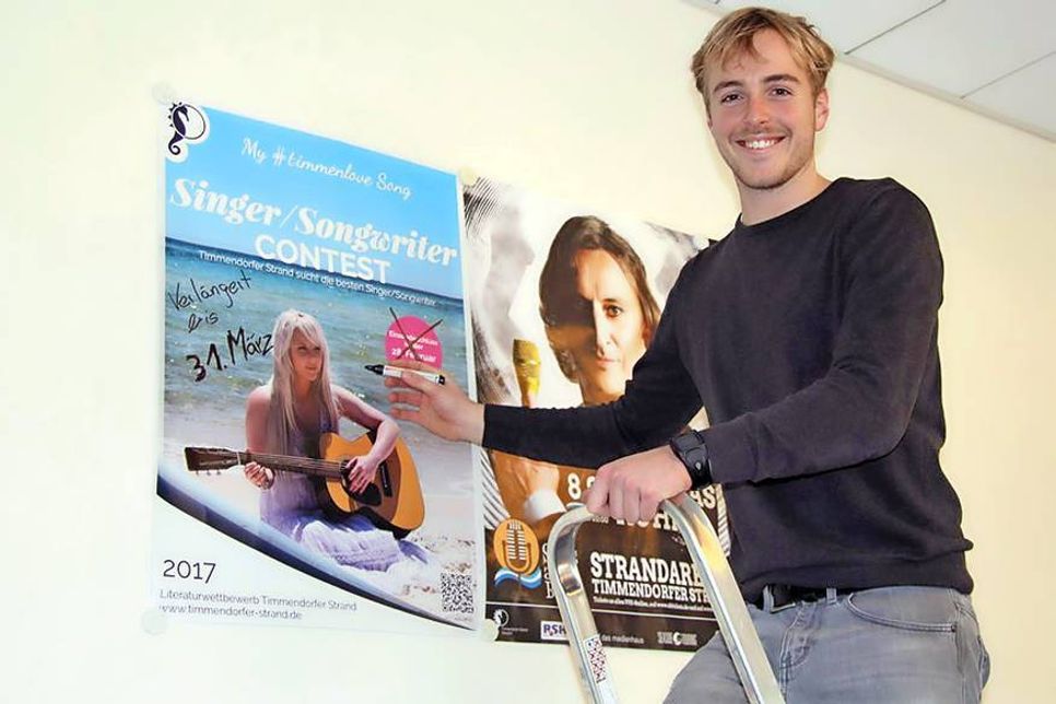 Friedrich Flüh von der TSNT GmbH ändert den Anmeldeschluss auf dem Plakat zum „Singer-Songwriter-Contest“.
