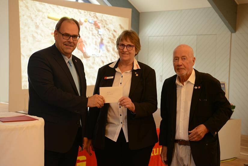 Ein sogenanntes „Flachgeschenk“ gab es von der Stadt, übergeben durch Bürgermeister Mirko Spieckermann (lks.) und Bürgervorsteher Sönke Sela an Vorsitzende Regina Block.