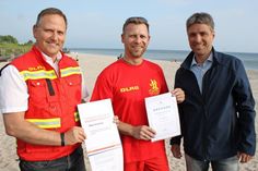 Maik Vornholz (Mitte) leistet seit 25 Jahren Wachdienst in Pelzerhaken. Es gratulierten Stephan Reil vom Tourismus-Service Neustadt-Pelzerhaken-Rettin (re.) sowie Klaus Holger Hecken.