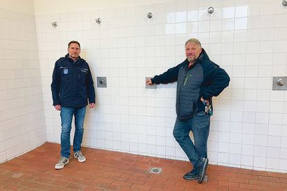 Die beiden Mitarbeiter der Gemeinde Stockelsdorf, Hausmeister Karsten Kammler (re.) und der für die bauliche Unterhaltung zuständige Dirk Schmidt in den dringend sanierungsbedürftigen Duschräumen.
