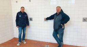 Die beiden Mitarbeiter der Gemeinde Stockelsdorf, Hausmeister Karsten Kammler (re.) und der für die bauliche Unterhaltung zuständige Dirk Schmidt in den dringend sanierungsbedürftigen Duschräumen.