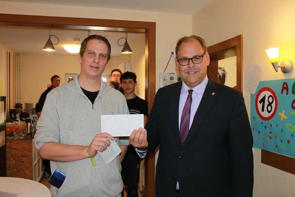 Scheck vom Chef: Erzieher und Jugendcafé-Leiter Falk Krüger (lks.) erhielt 200 Euro für die Einrichtung von Bürgermeister Mirko Spieckermann.