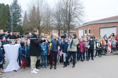 Dr. Katrin Engeln (rechts) assistiert Schulleiterin Corinna Ollech und Christopher F. Boldt, Leiter der Betreuten Grundschule, beim Durchtrennen des Absperrbandes.