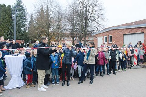 Dr. Katrin Engeln (rechts) assistiert Schulleiterin Corinna Ollech und Christopher F. Boldt, Leiter der Betreuten Grundschule, beim Durchtrennen des Absperrbandes.