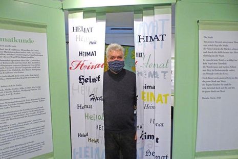 Zusammen mit dem Förderkreis der Kreisbibliothek hat der Künstler Jan-Olav Hinz die Ausstellung gestaltet, die man durch diesen Heimat-Vorhang betritt.