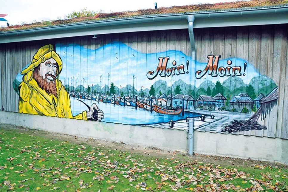 Ein neuer Hingucker in Niendorf/Ostsee: Der Netzschuppen der Fischer am Niendorfer Hafen mit dem neuen Kunstwerk von Feil, das vergangene Woche auf der Rückseite entstanden ist und von der Strandstraße aus zu sehen ist. (Foto: René Kleinschmidt)