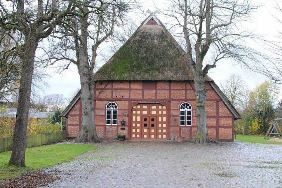 Zwei alte Linden flankieren die Dielentür, die „Groot Döör“, hinter der sich der historische Wirtschaftsbereich des Niederdeutschen Hallenhauses verbirgt.
