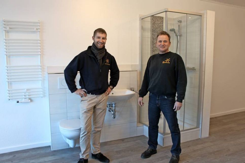 Finn-Thorben Runge mit Meister Stefan Broisch (re.) vor Ausstellungsstücken und Zubehör rund ums Bad.