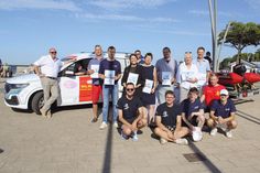 Olaf Techen, Vorsitzender der DLRG Lübecker Bucht e.V. (links), und sein Stellvertreter Thomas Walz (im Auto) mit einigen der Sponsoren und Jugendlichen des Ortsvereins vor dem neuen, gesponserten Mannschaftstransporter.