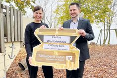 Steffen Braun, Leiter der Filiale Timmendorfer Strand der Volksbank Eutin, bei der symbolischen Scheckübergabe an Klinikleiterin Maren Harun auf dem Spielplatz des Caritas Westfalenhauses.