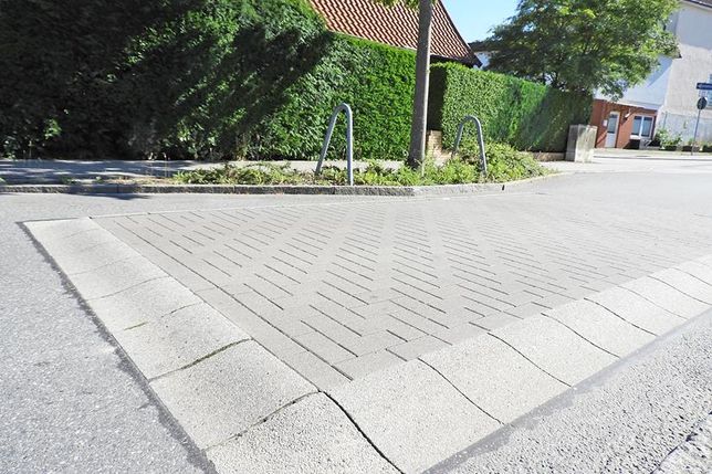 Eutin (aj). Mit beschaulicher Ruhe hatten Cornelia und Thorsten Maaß nicht gerechnet, als sie vor über 20 Jahren ihr Einfamilienhaus in der Charlottenstraße erwarben: „Man weiß, was einen erwartet, wenn man in der Stadt wohnen möchte“, sagt Cornelia Maaß pragmatisch. Vorbeifahrende Autos und die stete Geräuschkulisse der nahen Lübecker Landstraße sind für sie nicht der Rede wert. Seit aber nach der Sanierung der Straße eine Bodenschwelle direkt vor ihrem Haus für weniger Geschwindigkeit bei der Durchfahrt sorgen soll, wird der Lärm, den Fahrzeuge mit Ladung verursachen, wenn sie über die Tempobremse rumpeln, ein echtes Problem: „Es trübt einfach unsere Lebensqualität“, schildern das Ehepaar. Besonders laut wird es, wenn Busse, Lkw mit Ladung oder Pkw mit Anhänger über die Schwelle fahren. Und die Frequenz der passierenden Vehikel ist hoch.  „Wir haben das erst einmal hingenommen, aber dauerhaft war es so belastend, dass wir Kontakt mit dem Bürgermeister aufgenommen haben“, berichtet Co
