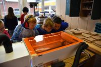 Staunende Blicke. Mit einem Laser wurden die eigenen Bilder auf Holzplatten gebrannt.