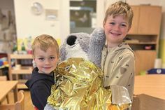 Anton und Levi haben aus dem Dreieckstuch einen Ring angefertigt und üben das Tragen des verletzten Koalabären.