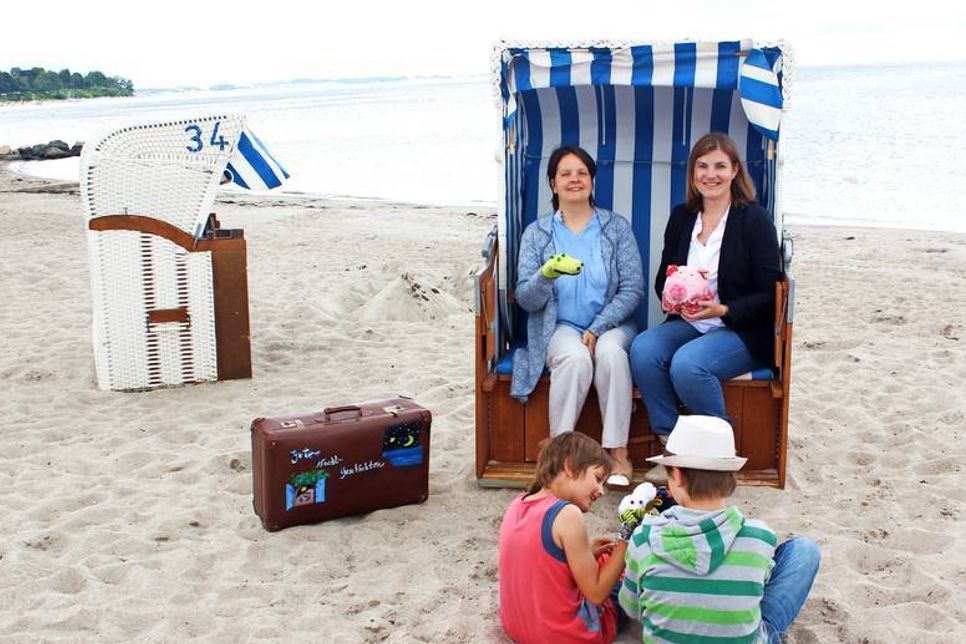 Pastorin Kristina Warnemünde (lks.) und Sonja Zastrow von der Tourismus-Agentur Lübecker Bucht sowie Paul und Ida freuen sich auf viele tolle Veranstaltungen am Strand.