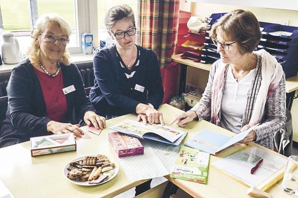 Die Lesepatinnen Petra Stern (von links), Claudia Didszun und Asta Noack machen sich mit dem Unterrichtsmaterial vertraut. (Foto: Martina Janke-Hansen/hfr)