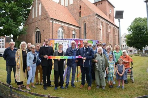 Die Beteiligten der Aktion Friedensbänder machen den Wunsch nach Frieden durch eine Installation an der Stadtkirche für alle sichtbar.