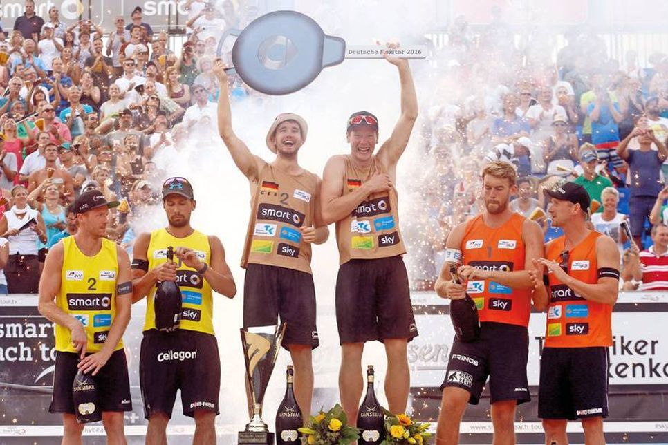 Erdmann/Kaczmarek (links, 2. Platz), die Deutschen Meister Boeckermann/Flueggen (Mitte) und die Drittplatzierten Matysik/Walkenhorst bei der Siegerehrung auf dem Centre Court in Timmendorfer Strand. (Fotos: Hoch Zwei/Joern Pollex)