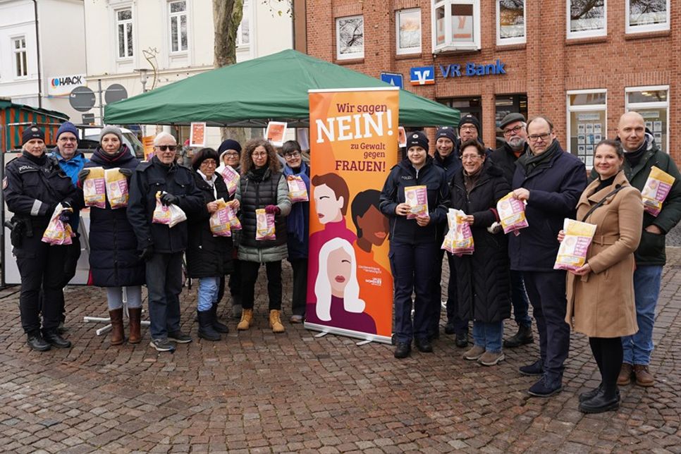 Vertreterinnen der Frauenberatung und Notruf Ostholstein, der Polizei, der Bundespolizei See, der evangelischen Kirche, der Omas gegen Rechts sowie Mitglieder des Weißen Rings, kommunale Politikerinnen und Politiker der Parteien Bündnis 90/Die Grünen, SPD und BGN, Gleichstellungsbeauftragte Natalia von Levetzow und Bürgermeister Mirko Spieckermann verteilten 500 Brötchentüten auf dem Marktplatz.