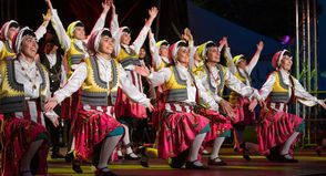 Tänzerinnen in traditionellen farbenfrohen Trachten begeistern das Publikum mit einer lebhaften folkloristischen Darbietung beim Folklorefest in Neustadt.
