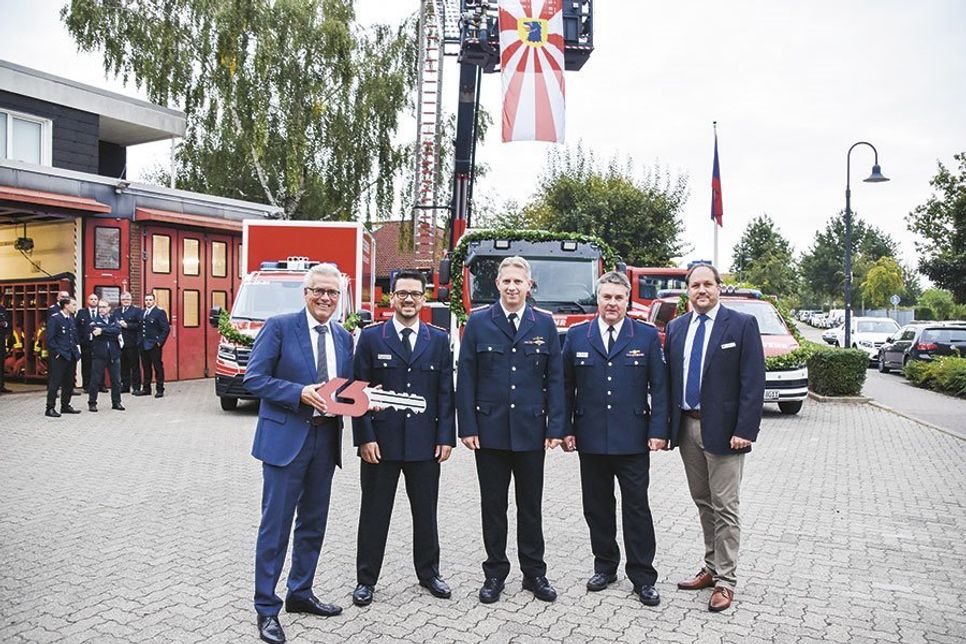 Bürgermeister Volker Owerien (von links), Gemeindewehrführer Patrick Bönig, Ortswehrführer Sebastian Levgrün, Kreiswehrführer Thorsten Plath und der stellvertretende Landrat Timo Gaarz bei der symbolischen Schlüsselübergabe vor den drei neuen Feuerwehrfahrzeugen.