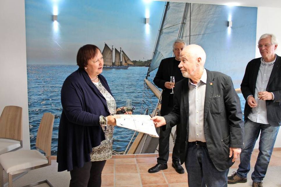 Bürgervorsteher Sönke Sela übergab Annette Schmitz ein Präsent der Stadt Neustadt.