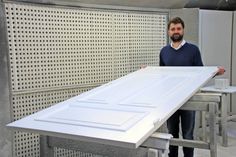 Diplomingenieur für Holztechnik Axel Mielke zeigt ein in der hauseigenen Lackiererei aufgearbeitetes Türblatt eines historischen Hauses.