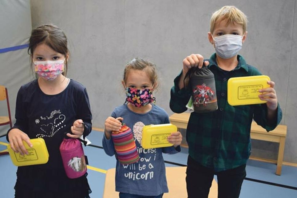 Johanna (v.l.), Finja und Hannes sind sich einig, die neuen Trink- flaschen und Brotdosen sind echt cool