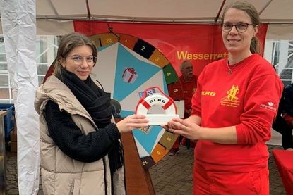 Mona Wiechmann vom eska-Kaufhaus (lks.) und Frederike-Christin Block von der DLRG Neustadt bei der Übergabe der Spende.