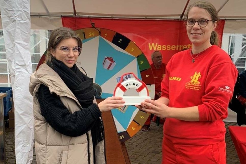 Mona Wiechmann vom eska-Kaufhaus (lks.) und Frederike-Christin Block von der DLRG Neustadt bei der Übergabe der Spende.