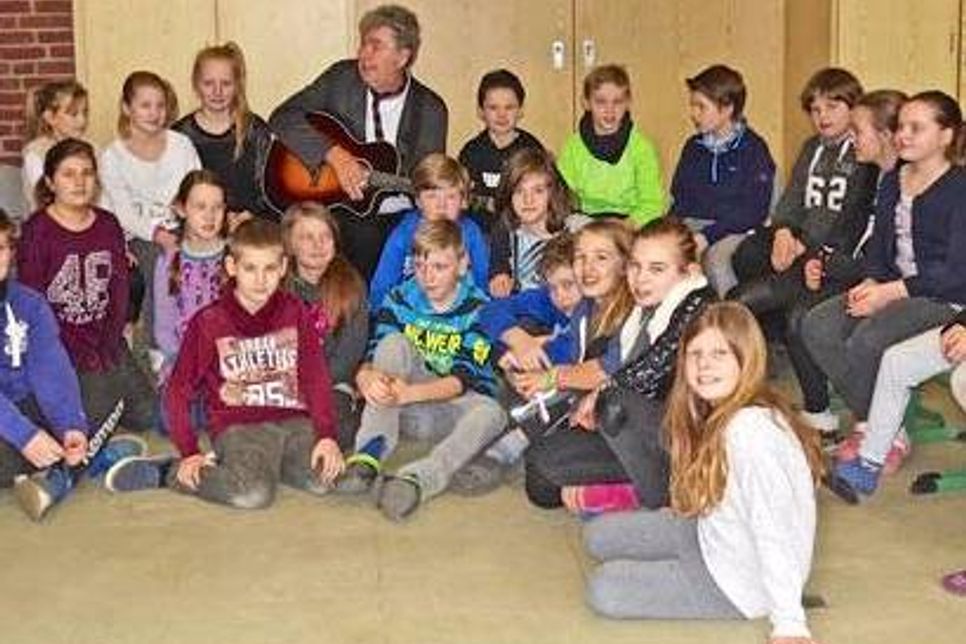 Fröhlich singt die Klasse 4a der Süseler Grundschule mit Wolfram Eicke.