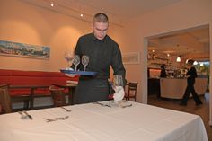 Eindecken für das Menü: Penibel ordnet Kevin Bestecke und Gläser an den Plätzen an – für ein perfektes Bild.