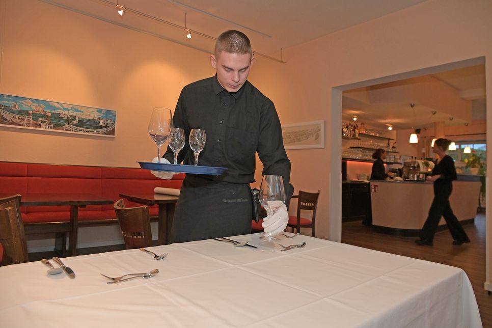 Eindecken für das Menü: Penibel ordnet Kevin Bestecke und Gläser an den Plätzen an – für ein perfektes Bild.