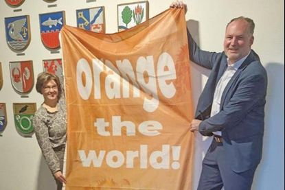 Yvonne Deerberg und Landrat Björn Demmin präsentieren die orangene Fahne der Aktion, die am 25. November in Plön gehisst wird.