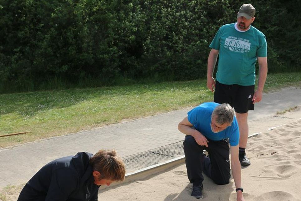 Roland Strawe (re.) hat gerade seinen Standweitsprung hinter sich - und jetzt messen die beiden Prüfer Peggy Bandelin und Reinhard Honerlage von der Sportvereinigung Pönitz, ob sein Sprung auch weit genug war.