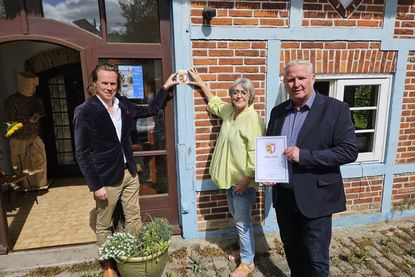 Dr. Philip Seifert, Leiter des Landesamtes für Denkmalpflege, Vereinsvorsitzende Brigitte Kemlein vom Förderverein Behrend-Haus Neuheikendorf e.V. und Bürgermeister Tade Peetz bei der Übergabe der Denkmalplakette für das Behrend-Haus.