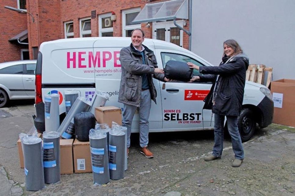 Die Verwaltungsleiterin vom Kieler Verein HEMPELS e. V., Vera Ulrich, freut sich über die Spende von zwölf Isomatten und zehn Schlafsäcken für Kieler Obdachlose, die sie vom Lions-Club Sconeberg Mitglied Sven Möllemann erhält. Die Spendenaktion wurde möglich durch eine finanzielle Unterstützung durch die VR Bank Ostholstein Nord-Plön eG.