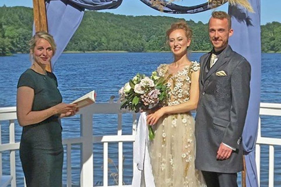 Anna und Christian “spielen” ein Brautpaar, sind auch in Wirklichkeit ein Paar und  stellen sich vor einer Traumkulisse einem Fotografen. Eine solche Hochzeit in wunderschönem Ambiente ist buchbar. – Links: Lena Willers war als Traurednerin vor Ort und kümmerte sich auch um die festliche Dekoration.