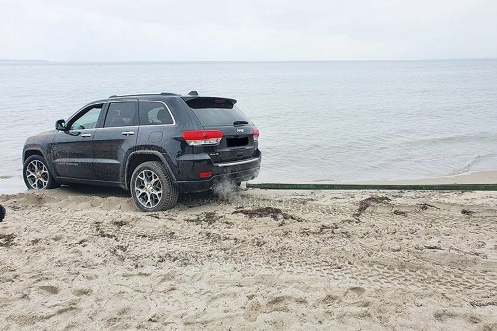An der Orstgrenze zwischen Scharbeutz und Timmendorfer Strand hat sich ein Jeep am Strand festgefahren.