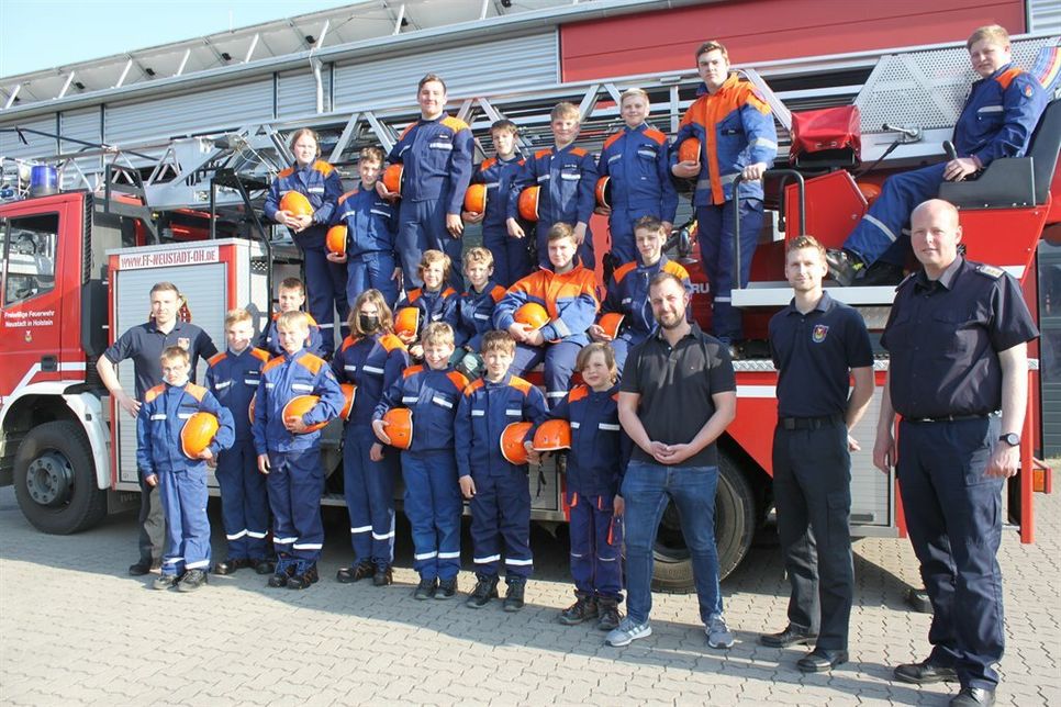 Sponsor Denis Schlüter (vorne 3. v. re.) mit dem stellvertretenden Stadtwehrführer Sebastian Papke (vorne re.), Jugendfeuerwehrwart Marcel Fuchs (vorne 2. v. re.), dem stellvertretenden Jugendfeuerwehrwart Fynn Niklaas Lull (lks.) und den Jugendlichen bei der Spendenübergabe.