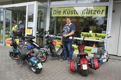 Bernd von Lysander inmitten seiner Elektroflotte vor dem Geschäft in Kellenhusen.