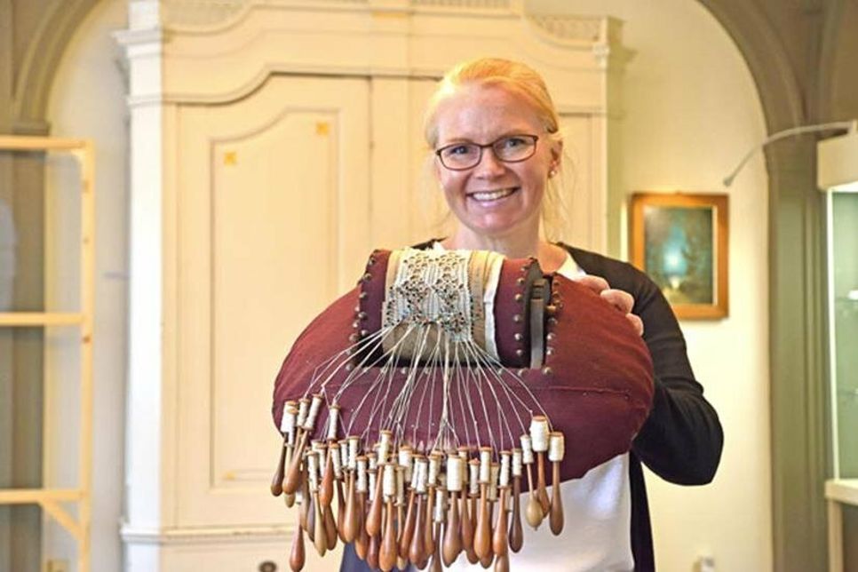 Museumsleiterin Julia Meyer präsentiert ein historisches Klöppelkissen aus der Zeit vor 1800.