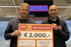 Marktleiter Ayhan Deniz (re.) überreichte den symbolischen Scheck an Ortswehrführer Sebastian Levgrün.