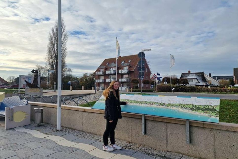 Marie Wandelt, Auszubildende beim Tourismus-Service Kellenhusen, freut sich über die neu aufgestellten Übersichtstafeln der Promenade.