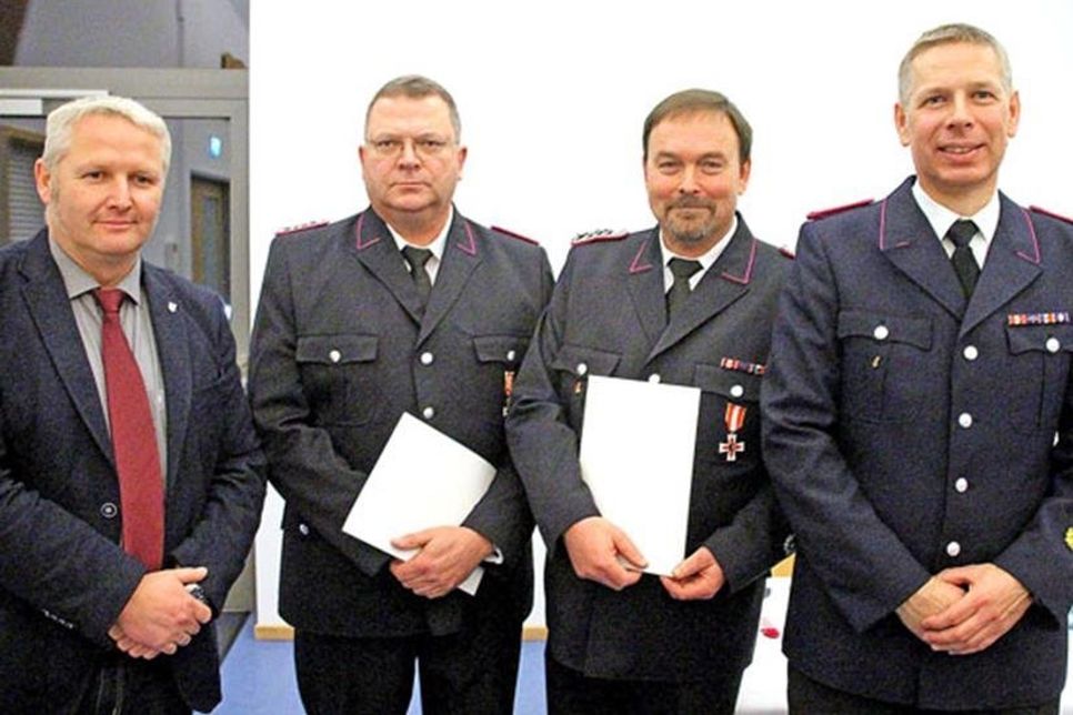 Bürgermeister Tade Peetz zeichnete Marco Wiesner und Olaf Lachmann mit dem goldenen Brandschutzehrenzeichen am Bande in Gold aus. Rechts: OWF Jörg Taube