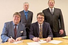 Die Kugelschreiber sind zur Besiegelung des Kooperationsvertrages gezückt. Berufsschulleiter Carsten Ingwertsen-Martensen (l.) und FH-Dekan Prof. Dr. Martin Ryschka. – Dahinter (v.l.): Prof. Dr.-Ing. Helmut Bergmann (Studiengangsleiter an der FH) und Mathias Knorn, Lehrkraft für Elektrotechnik an der KBS.