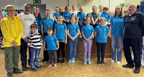 Die Kinder und der Vorsitzende des Neustädter Volkstanzkreises, Jürgen Nitze (re.), bedanken sich bei Familie Singh für die neuen T-Shirts.