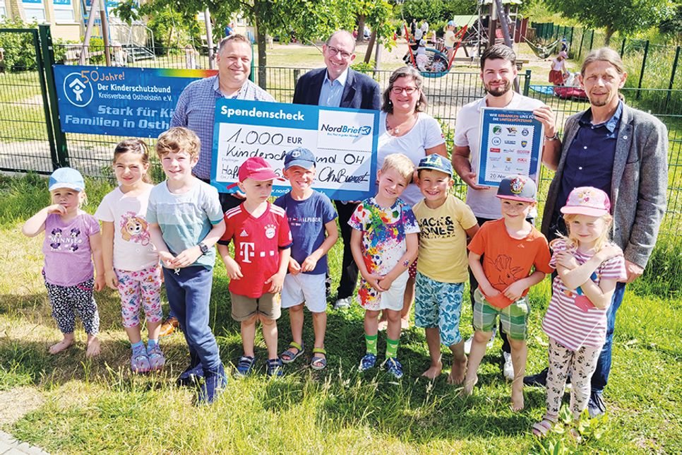 Spendenübergabe von 1.000 Euro durch Nordbrief-Vertreter an den Kinderschutzbund Ostholstein im Sommer 2023 vor der Kita „Ostseekinder“ in Haffkrug .