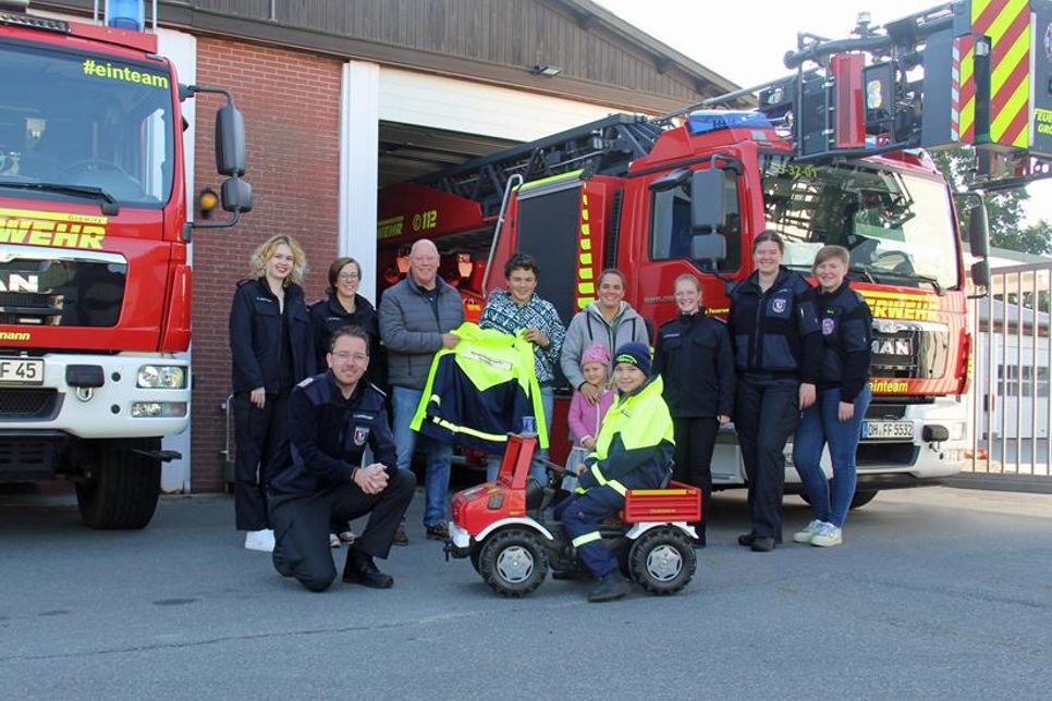 Udo Tegtmeyer mit Familie (Mitte) sowie die Leitung der Kinderfeuerwehr Silke Marks und Johanna Schneekloth, Betreuerinnenteam der Kinderfeuerwehr, Ortswehrführer Jacob Revenstorf und Löschlöwin Lotta Bibow.