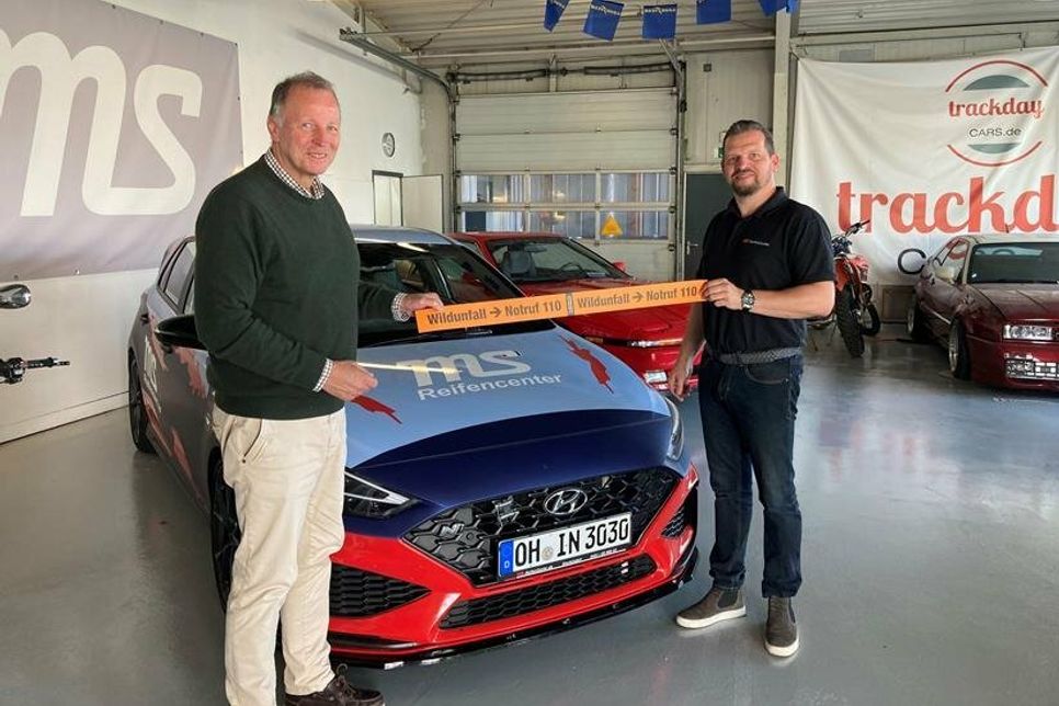 Der Öffentlichkeitsbeauftragte der Kreisjägerschaft Oldenburg, Jan-Pieter Frick (re.), übergibt die Markierungsstreifen an Markus Schmidt